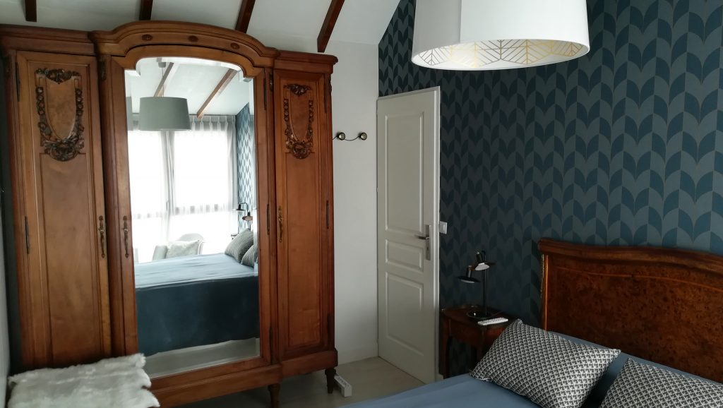 C'est la décoration d'une chambre d'amis à Reims avec armoire et tête de lit au charme ancien